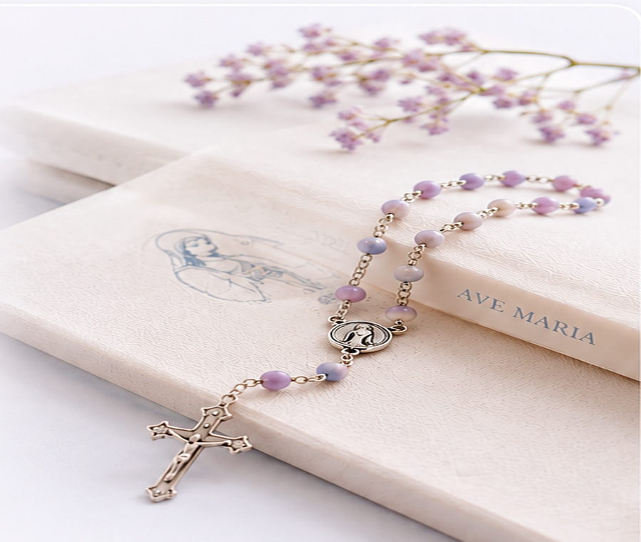 A rosary beside a prayer book featuring the Virgin Mary